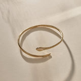 Serpent Snake Arm Cuff in gold at an angle, showing the coiled, open design.
