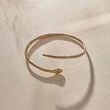 Serpent Snake Arm Cuff in gold from the side, showing the snake head and open ends.