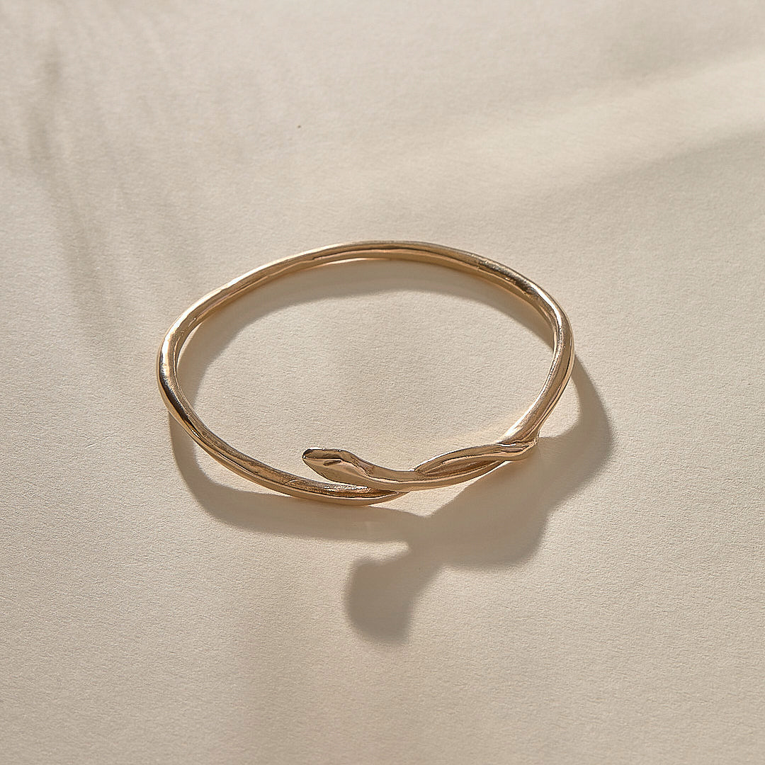 Serpent Snake Bangle in bronze from the side, with the snake head resting on the band.