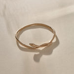 Serpent Snake Bangle in bronze from the side, with the snake head resting on the band.
