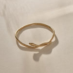Serpent Snake Bangle in gold at an angle, the snake coiling over the band.