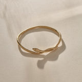 Serpent Snake Bangle in gold at an angle, the snake coiling over the band.