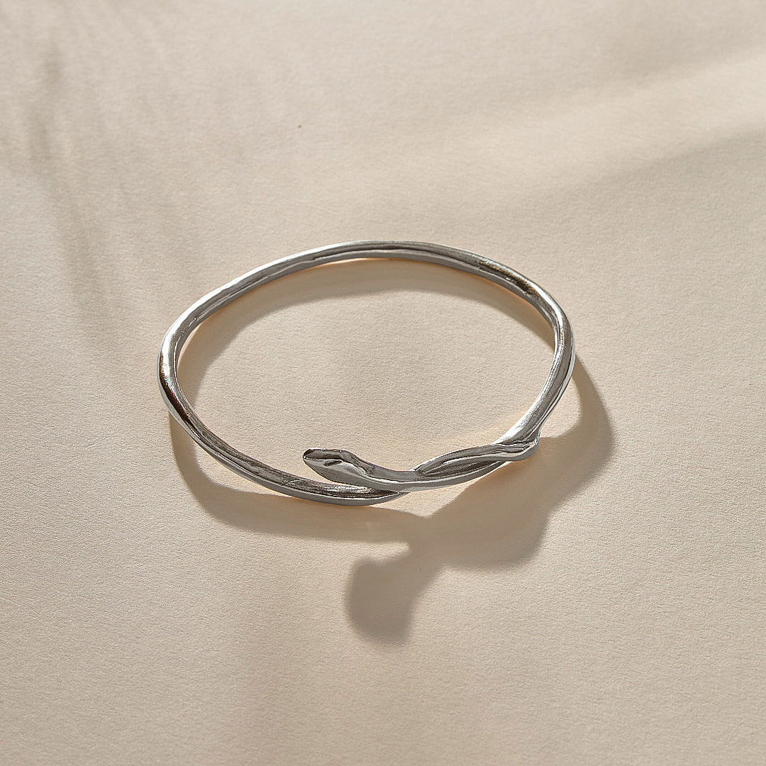Serpent Snake Bangle in sterling silver from the side, with the snake head resting on the band.