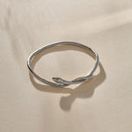 Serpent Snake Bangle in sterling silver from the side, with the snake head resting on the band.