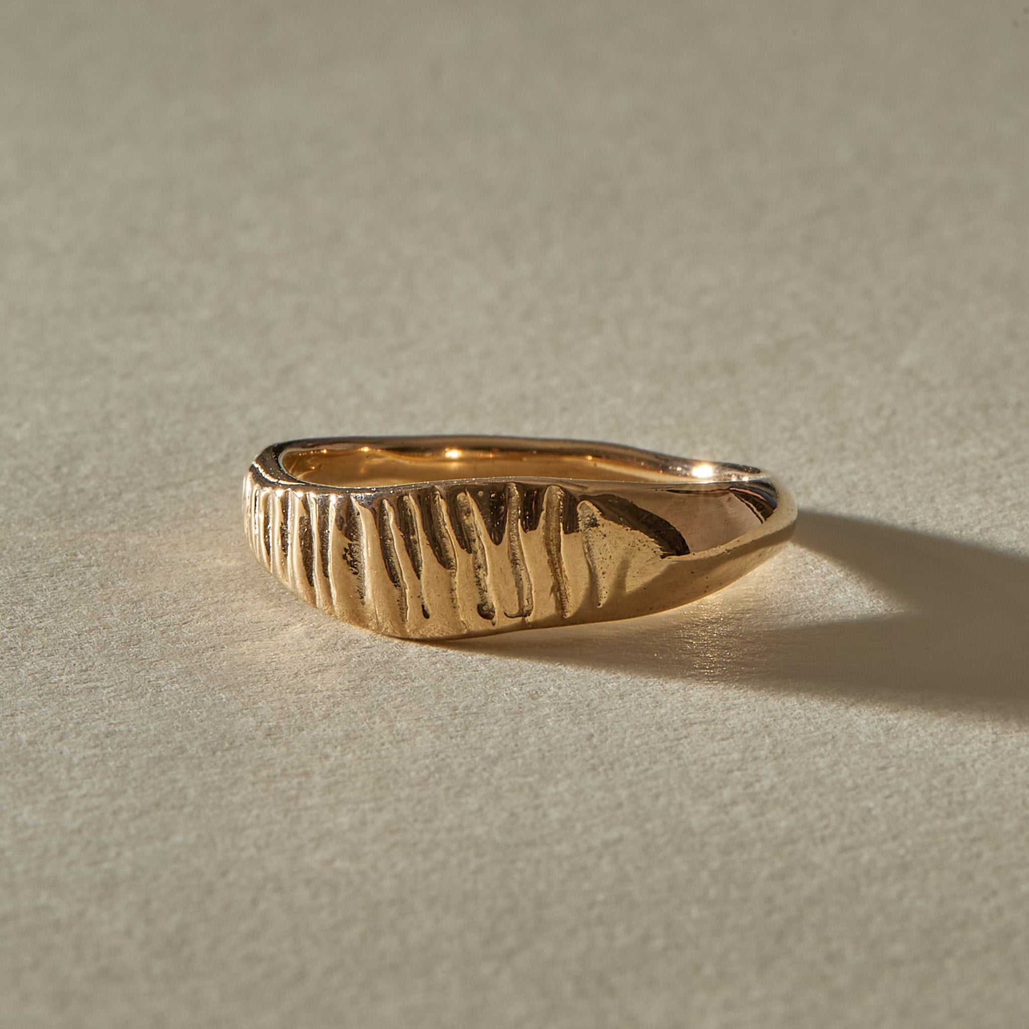 Smoke Ring in solid recycled gold, angled view of the carved smoke texture