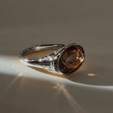 Smoky Quartz Signet Ring in recycled sterling silver, angled view with light catching the faceted stone