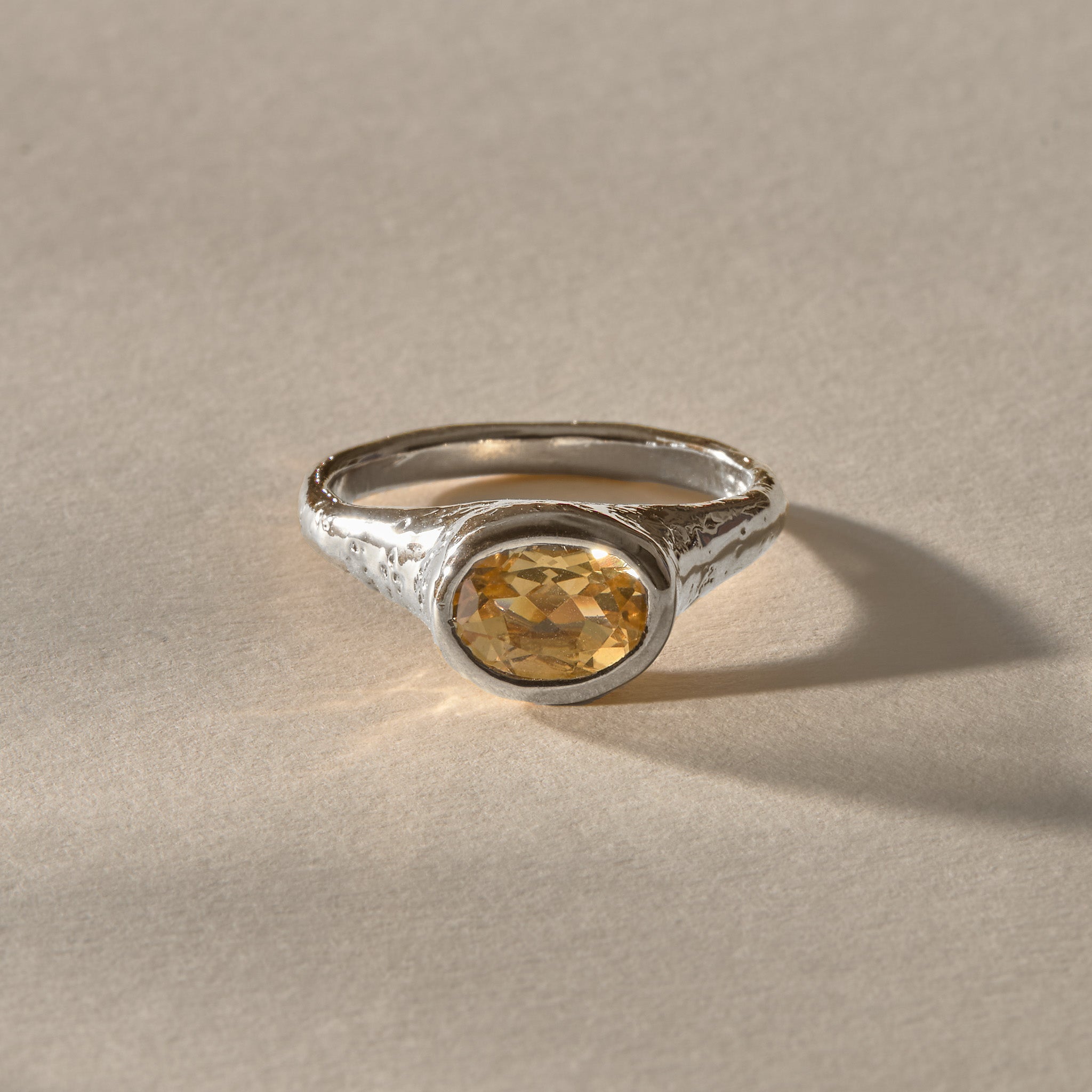 Solara citrine signet ring in silver from the front, the golden citrine glowing against the textured silver.