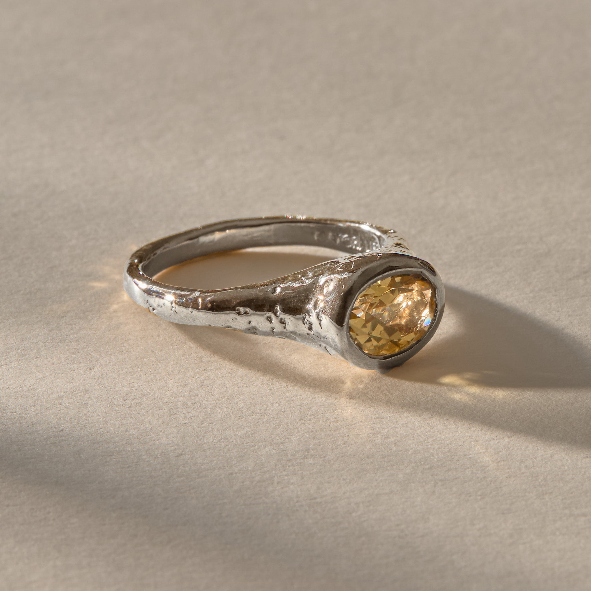 Solara Citrine Signet Ring in recycled sterling silver, a faceted oval golden citrine in a smooth bezel on an organically textured band.