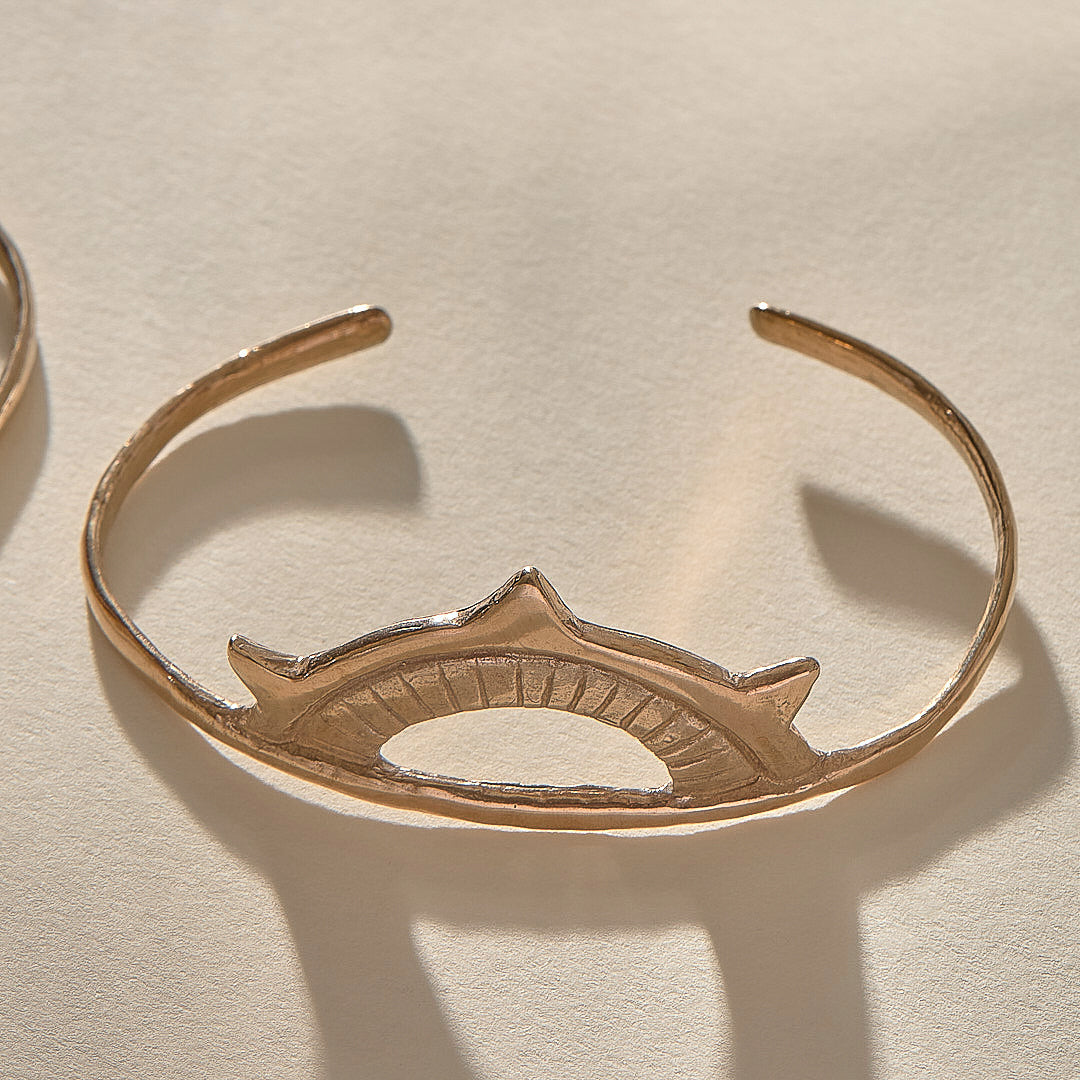Sunkeeper Cuff in bronze, a delicate open cuff with a rising sun face.