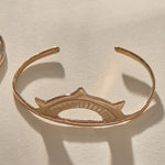 Sunkeeper Cuff in bronze, a delicate open cuff with a rising sun face.