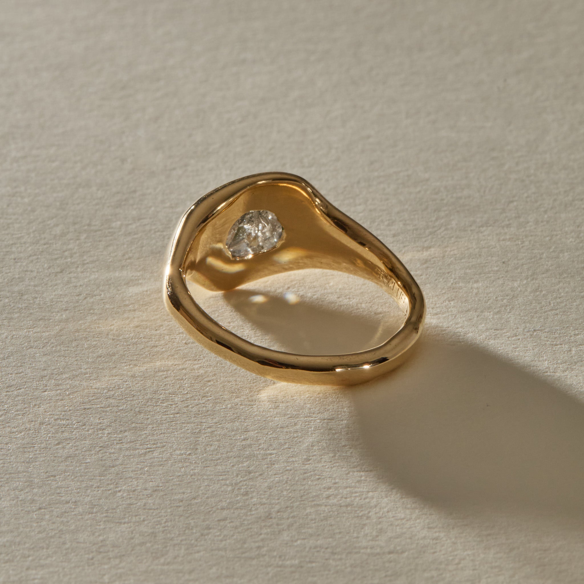 Back of the Vía Láctea I ring, showing the gold setting beneath the raw diamond and the polished band.