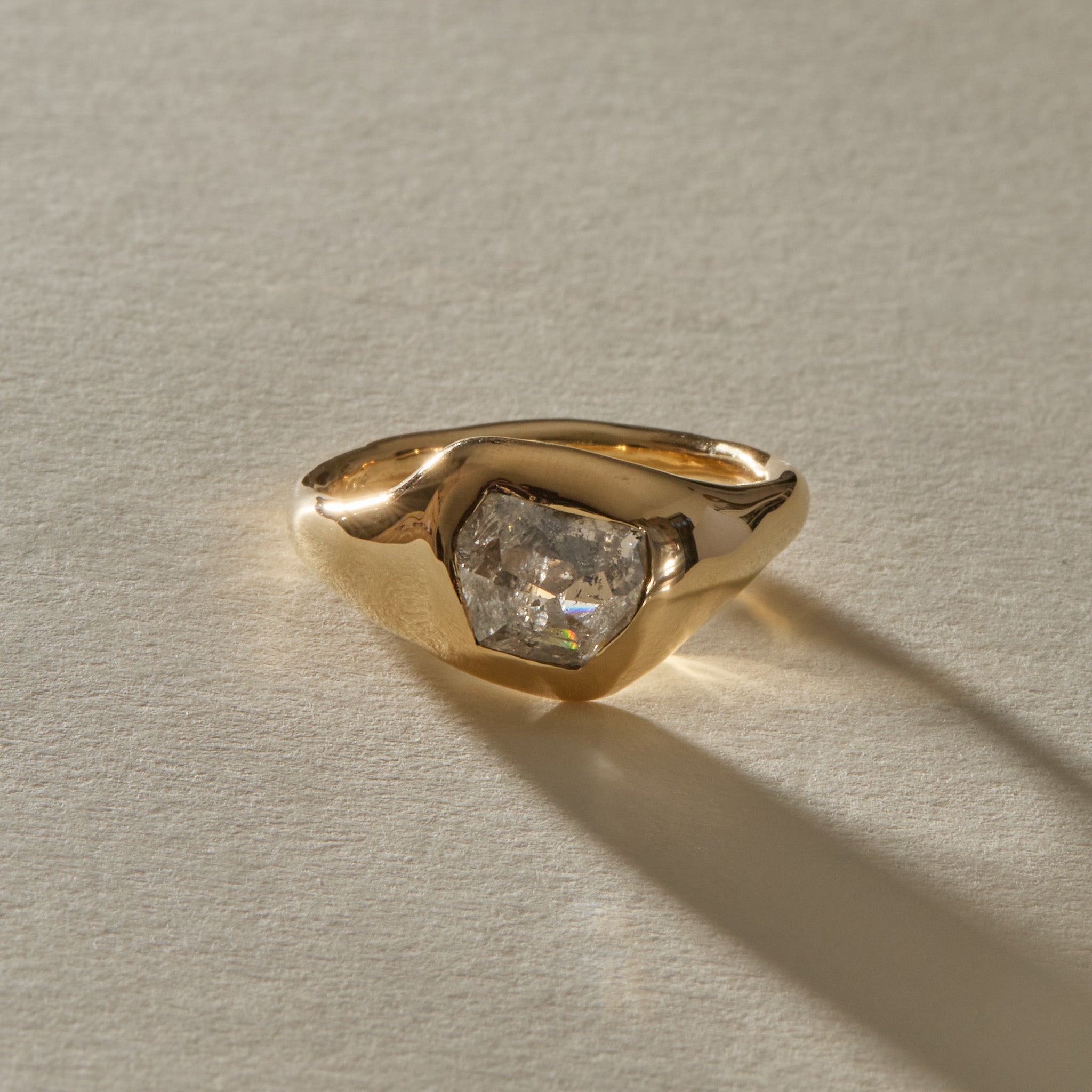Vía Láctea I ring from the front, showing the galaxy-like inclusions of the raw salt and pepper diamond in its sculptural gold setting.