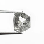 The raw salt and pepper diamond for Vía Láctea I held in tweezers, showing its smoky, star-like inclusions.