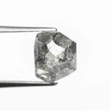The raw salt and pepper diamond for Vía Láctea I held in tweezers, showing its smoky, star-like inclusions.