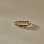 Vida Sapphire Ring at an angle, a thin organic gold band with a single sapphire showing at the front.
