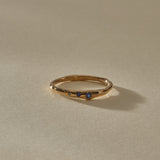 Vida Sapphire Ring at an angle, a thin organic gold band with a single sapphire showing at the front.
