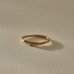 Vida Sapphire Ring from the front, showing three tiny blue sapphires set along the gently curved gold band.