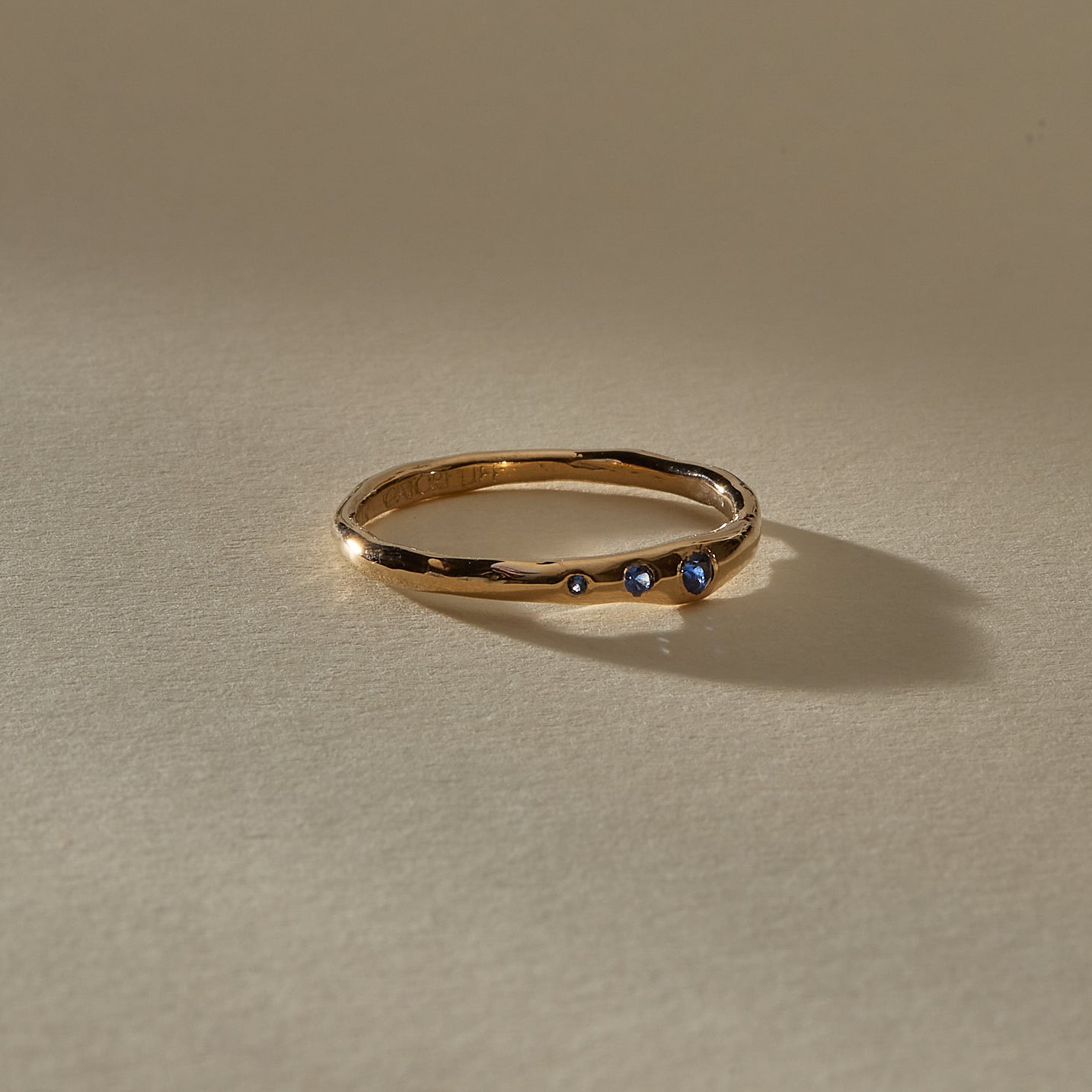 Vida Sapphire Ring in solid gold from the side, with the blue sapphires catching the light.