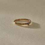 Vida Sapphire Ring, a delicate organic band in solid recycled gold set with three graduated blue sapphires, in soft sunlight.