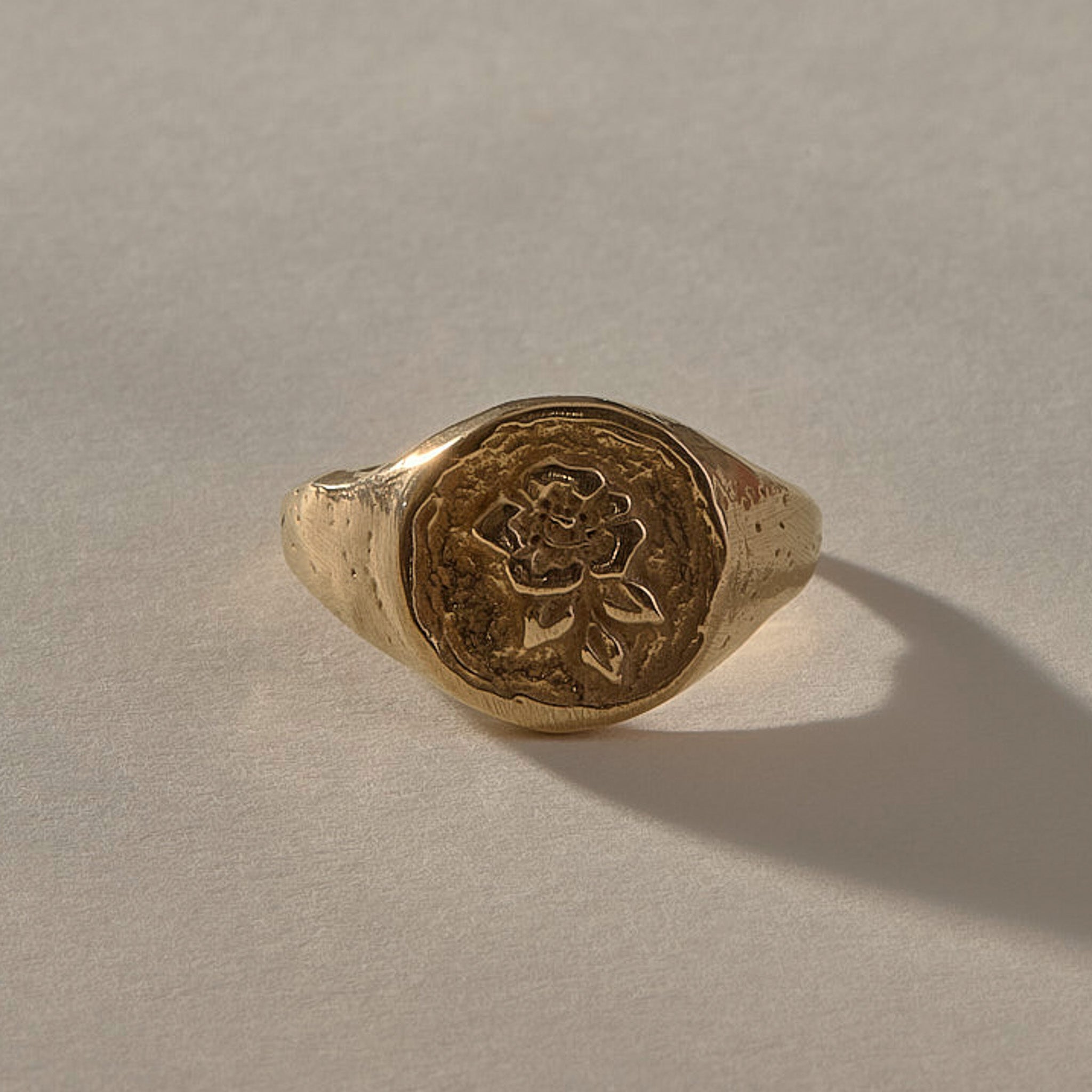 Wild Rose Ring in solid recycled gold, front view of the rose signet face
