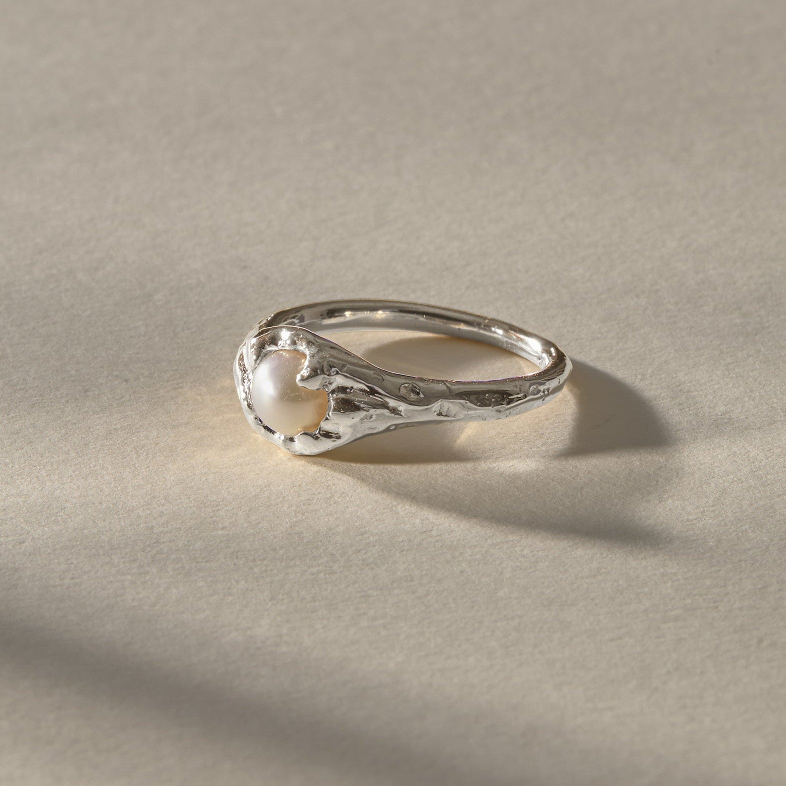 Yemayá Pearl Ring in silver at an angle, showing the wave-like texture around the pearl.
