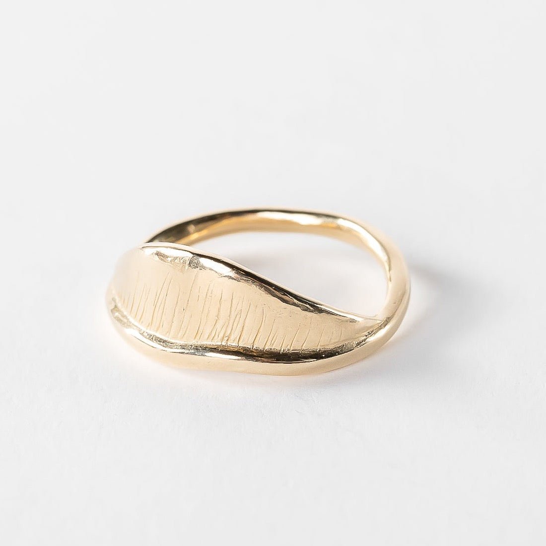 Devotions Wave Ring in solid recycled gold on a white background, showing the fine carved lines across the wave.