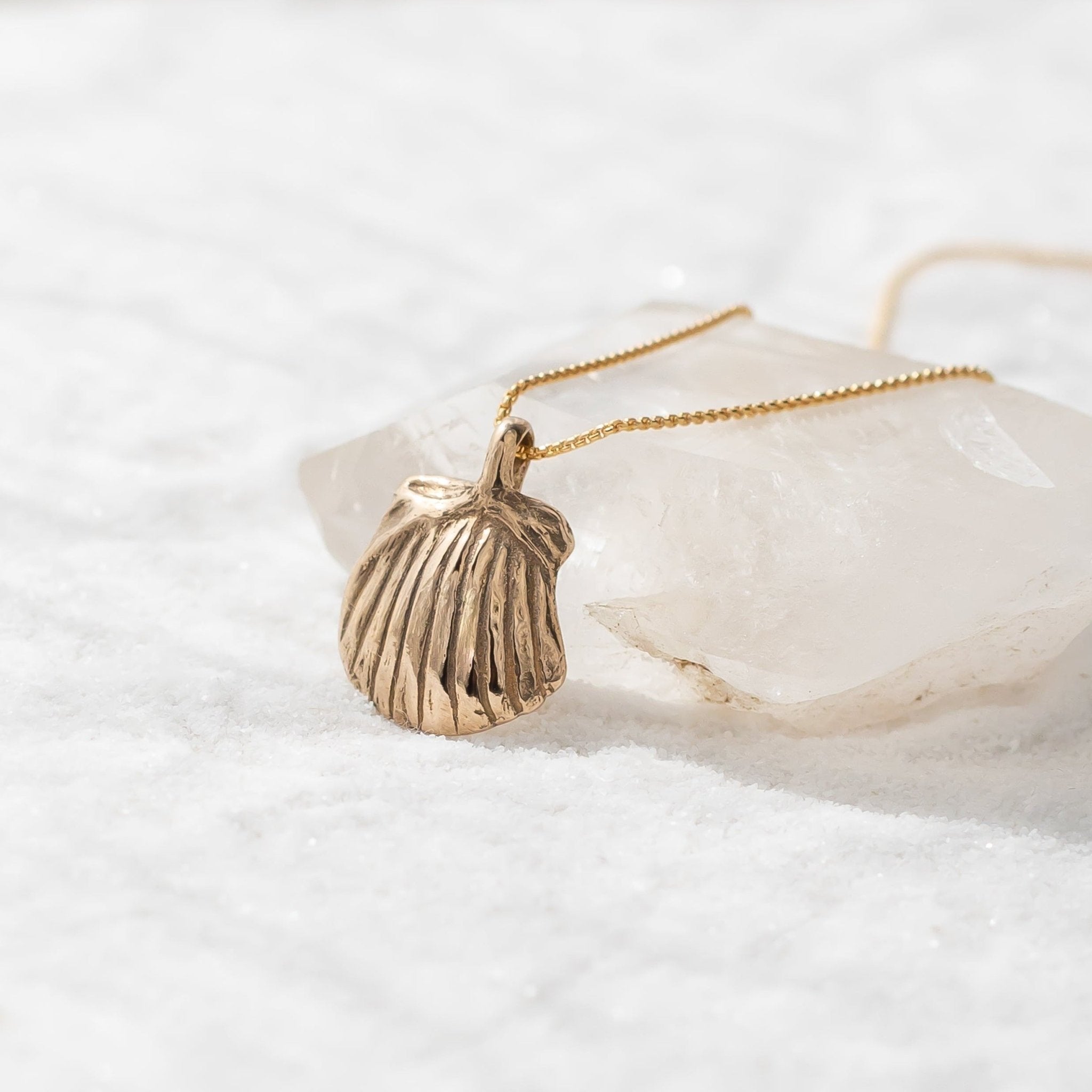 Elysian Shell Necklace pendant resting on a quartz crystal.