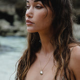 Elysian Shell Necklace worn by a model by the sea.