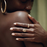 Model's hand resting on her shoulder, wearing the Scarab Ring with stacked rings