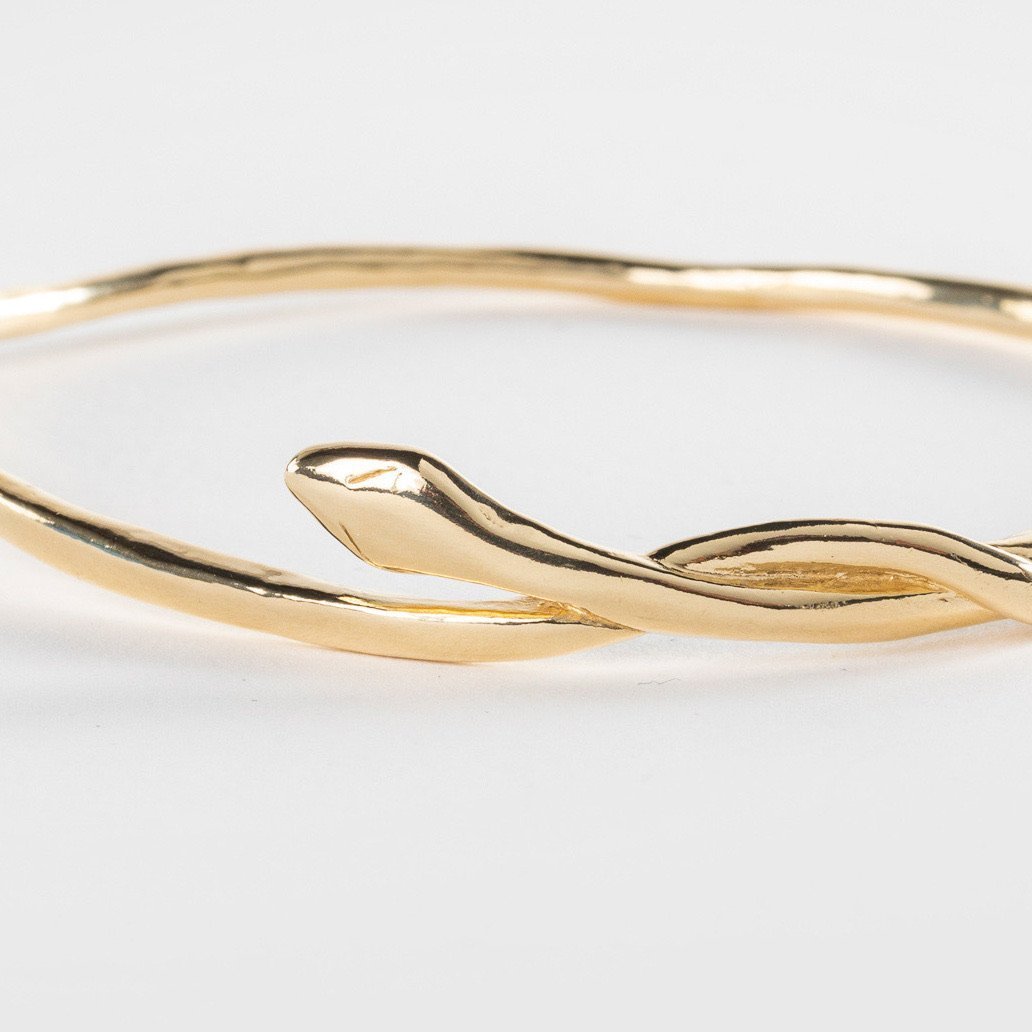 Serpent Snake Bangle in gold on a white background, showing the snake wrapped around the band.