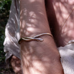 Serpent Snake Bangle worn on the wrist in dappled sunlight.
