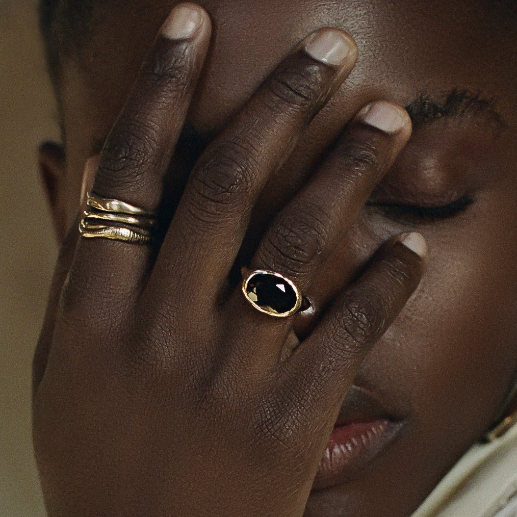 Model with her hand over her face, wearing the Smoky Quartz Signet Ring with stacked Catori Life rings