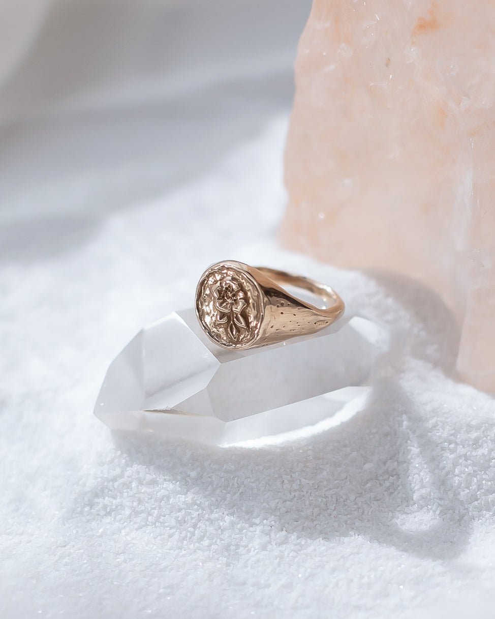 Wild Rose Ring in recycled bronze resting on a white crystal