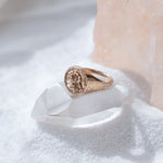 Wild Rose Ring in recycled bronze resting on a white crystal