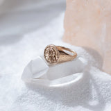 Wild Rose Ring in recycled bronze resting on a white crystal